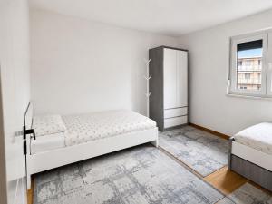 a white bedroom with a bed and a window at Real Residence Bugojno in Bugojno