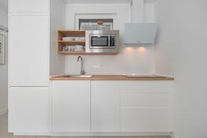 a kitchen with white cabinets and a microwave at Sunny Guargacho4 Retreat-South Tenerife in Guargacho +21 photos