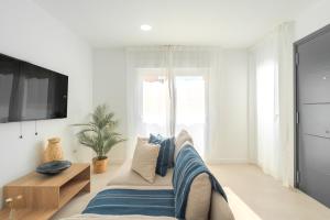 a living room with a couch and a tv at Sunny Guargacho4 Retreat-South Tenerife in Guargacho