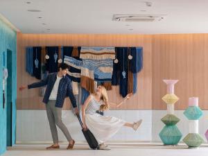 a man and a woman with a suitcase in a room at ibis Styles Phuket Bangtao in Bang Tao Beach