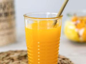a glass of orange juice with a spoon in it at Ibis Styles Saint Germain en Laye in Saint-Germain-en-Laye