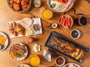 a wooden table with breakfast foods and drinks on it at Ibis Styles Saint Germain en Laye in Saint-Germain-en-Laye