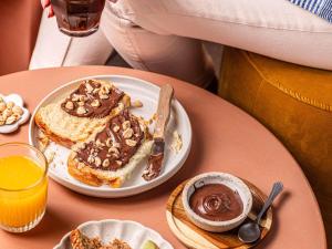 a table with a plate of pancakes with chocolate and nuts at Ibis Styles Saint Germain en Laye in Saint-Germain-en-Laye
