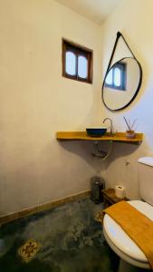 a bathroom with a toilet and a mirror on the wall at Chalé Orion in Lençóis