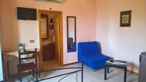 een woonkamer met een blauwe stoel en een televisie bij Azienda Agrituristica Piccolo Ranch in San Pietro