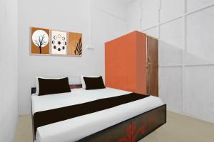 a bedroom with a bed with a red cabinet at SPOT ON Milan Hotel in Hāthras