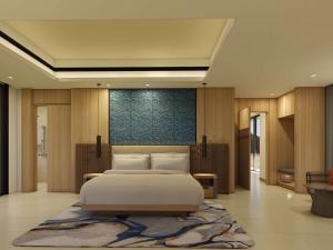 a bedroom with a large bed and a rug at Mövenpick Resort Carita in Serang