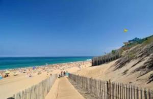 a sandy beach with a fence and the ocean at maison Labenne in Labenne