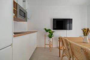eine Küche und ein Esszimmer mit Tisch und Fernseher in der Unterkunft Sunny Guargacho5 Retreat-South Tenerife in Guargacho