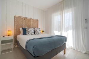 ein weißes Schlafzimmer mit einem Bett mit blauen Kissen in der Unterkunft Sunny Guargacho5 Retreat-South Tenerife in Guargacho