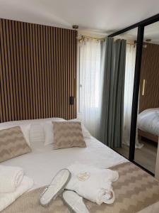 a bedroom with a white bed with towels on it at Marathi élégance T2 neuf avec SPA privatif in Biscarrosse