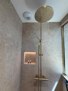 a shower with a shower head in a bathroom at Marathi élégance T2 neuf avec SPA privatif in Biscarrosse +24 photos