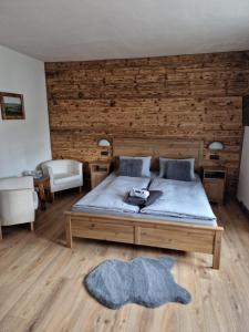 a bedroom with a large bed and a wooden wall at Pension MAX in Pernink