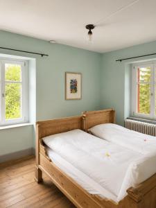 a bedroom with two beds and two windows at Gasthaus Crestasee in Flims