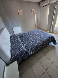 a bedroom with a bed with a blue comforter at Depto Civora 1 in Villa Regina
