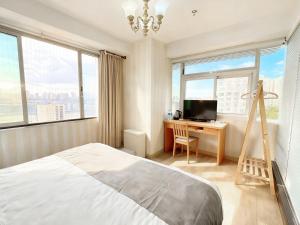 a bedroom with a bed and a desk with a television at 枳兮酒店 渝中区解放碑 in Chongqing