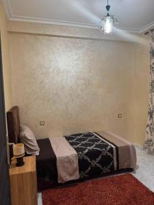a bedroom with a bed and a wall at Cozy two bedroom apartment in Meknès