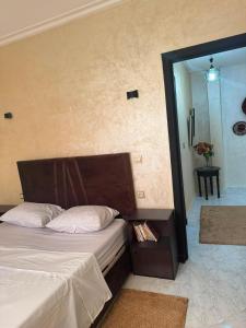 a bedroom with a bed with a wooden head board at Cozy two bedroom apartment in Meknès +4 photos
