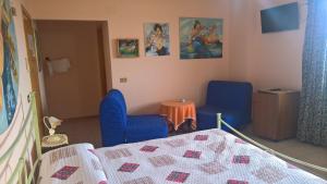 een slaapkamer met 2 blauwe stoelen en een bed bij Azienda Agrituristica Piccolo Ranch in San Pietro