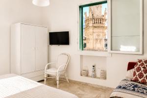 a bedroom with a chair and a window at Colonna Apartment Ostuni in Ostuni