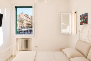 a white room with a couch and a window at Colonna Apartment Ostuni in Ostuni