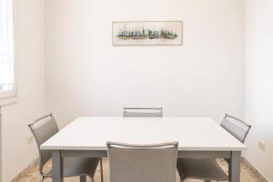 a meeting room with a white table and chairs at Colonna Apartment Ostuni in Ostuni +14 photos