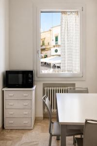 a dining room with a table and a window at Colonna Apartment Ostuni in Ostuni