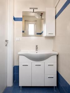 a bathroom with a white sink and a mirror at Colonna Apartment Ostuni in Ostuni