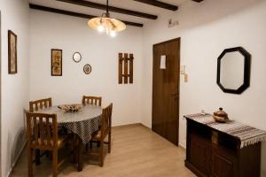 a dining room with a table and chairs and a mirror at Chios Studios Kalamari in Vrontádos +6 photos