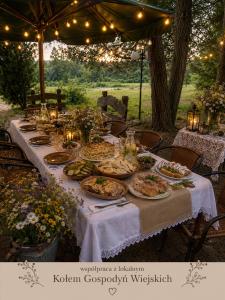 a long table with plates of food on it at Magiczny Dom nad Bugiem in Pętkowo Wielkie