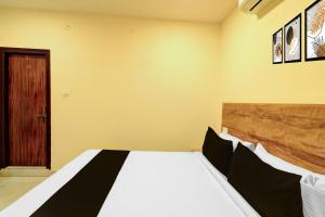 a bedroom with a bed and a door at Super Hotel O Nivara in Hyderabad +23 photos