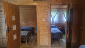 a small room with two beds and a window at Domki u Wiki in Niechorze