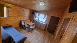 a small room with a table in a wooden cabin at Domki u Wiki in Niechorze