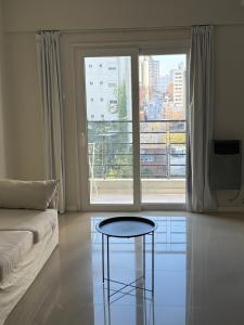 a living room with a couch and a table in front of a window at Monoambiente Premium in La Plata