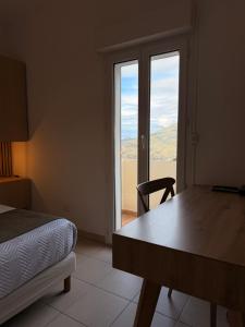 a bedroom with a bed and a table and a window at Au bon clocher in Canari