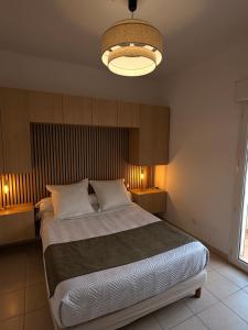 a bedroom with a large bed and a light fixture at Au bon clocher in Canari