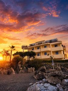a building with a sunset in front of it at Beach Hotel Terracotta in Sapri