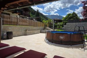 a patio with a hot tub in a yard at Pension Monteneu in Bartholomäberg