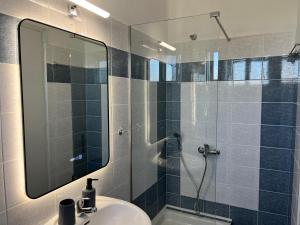 a bathroom with a sink and a shower with a mirror at Riverside Rooms Ammoudia in Ammoudia +47 photos