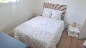 a bedroom with a bed with white sheets and pillows at Chambre d'hôtes Nova, petit déjeuner en supplément 5 euros par personne in Saint-Pair-sur-Mer