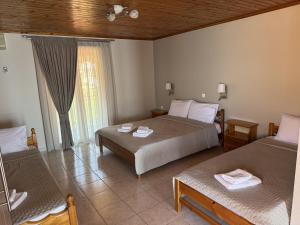 a hotel room with two beds and a window at Stella Studios in Ilia +19 photos