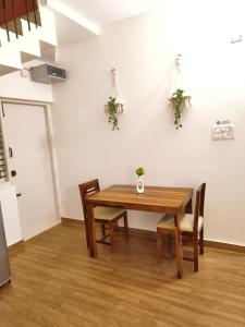 a dining room with a wooden table and chairs at Flickstays Hazel in Bangalore