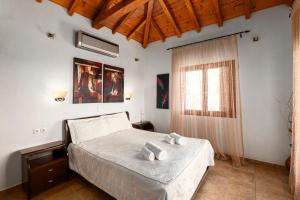 a bedroom with a bed and a window at Skiathos Garden Cottages in Skiathos +274 photos