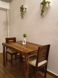 a wooden table with two chairs and a vase on it at Flickstays Hazel in Bangalore
