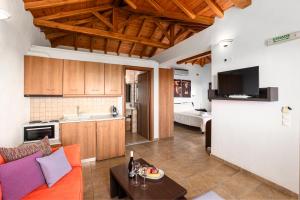 a living room with a couch and a kitchen at Skiathos Garden Cottages in Skiathos