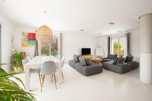 a white living room with a white table and chairs at Villa Marius in Albi