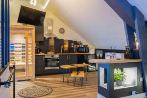 a kitchen with black cabinets and a table with chairs at L'Intemporel Éclipse Suite Spa Privatif in Champagne-sur-Oise
