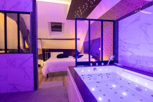a purple bathroom with a tub and a bed at L'Intemporel Éclipse Suite Spa Privatif in Champagne-sur-Oise