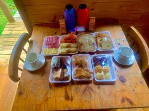 a wooden table with trays of food on it at Cabana Recanto dos Aparados in Cambará