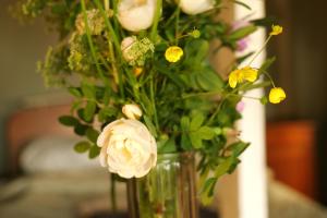 a vase filled with flowers on a table at Minimalist riverside hideout in Riga